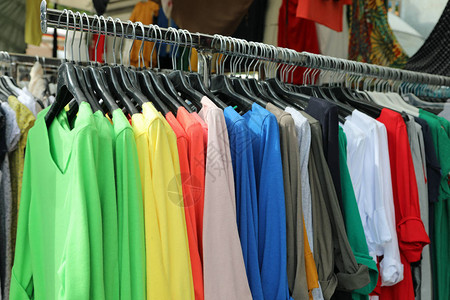 衣服在市场上衣架上挂着多件有色图片