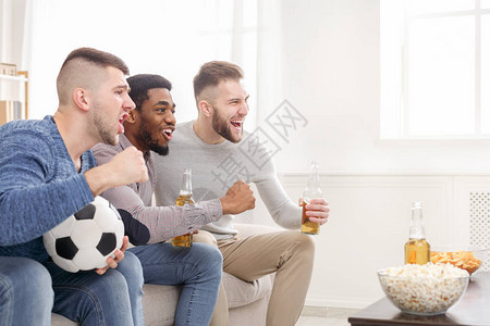 男足球迷为最喜爱的球队欢呼在家喝啤图片