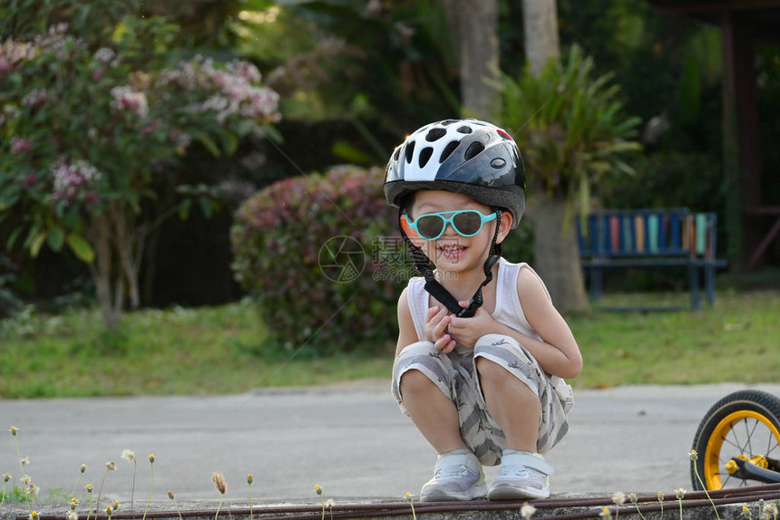 儿童快乐时戴太阳眼镜和运动头盔图片