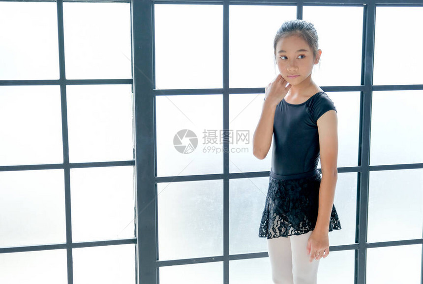 芭蕾舞女孩站在玻璃墙前图片