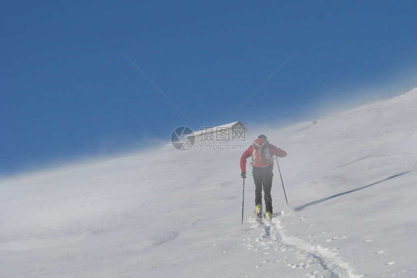 滑雪登山者在山间的风暴中攀爬图片