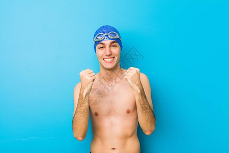 游泳的年轻男子欢呼无忧和兴奋图片
