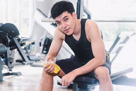 体育运动员在健身房用能量饮料瓶保有体操图片