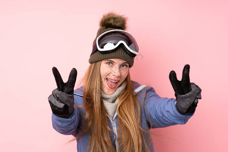 穿着滑雪眼镜的滑雪少女与孤立的粉红背景相伴图片
