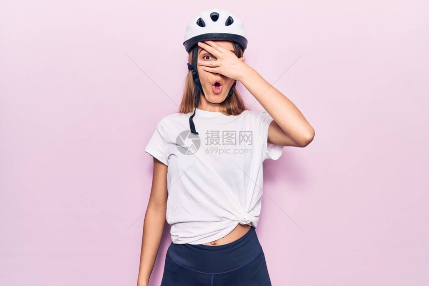 戴着自行车头盔的年轻美女用手捂着脸和眼睛图片