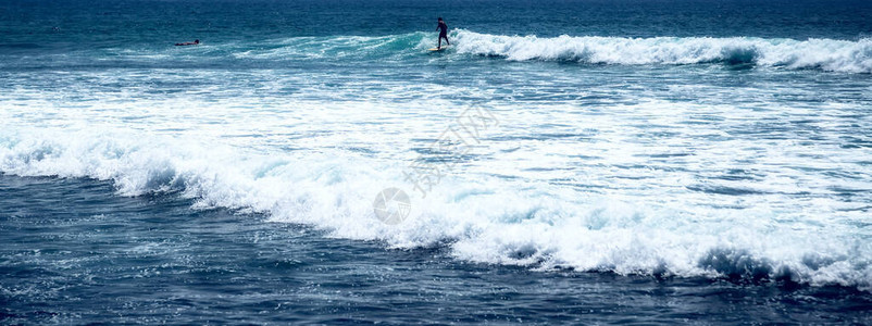 冲浪者在冲浪板上的海水飞溅蓝色透明冲浪新鲜海水背景巴厘岛图片