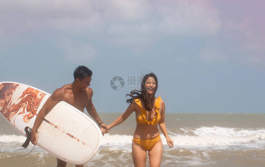 年轻的女士和英俊的男子拿着右手的冲浪板用快乐的感觉说话模特装扮满脸大图片