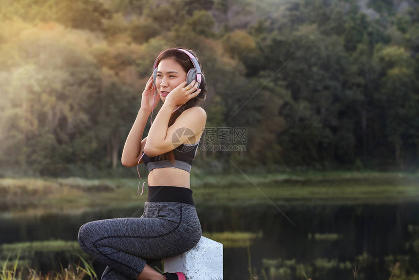 运动妇女休息锻炼用耳机听音图片