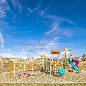 广场白天设备齐全的小型儿童游乐场在阳光明媚的蓝天下背景图片