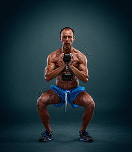 用哑铃进行腿部锻炼的肌肉男图片