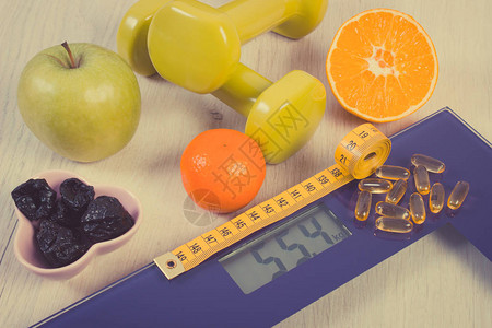 数字浴室秤上的卷尺测量人体重量健身哑铃新鲜水果和片剂补充剂健康的生图片
