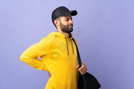 带着运动袋的摩洛哥青年男子在紫色背景下被孤立图片