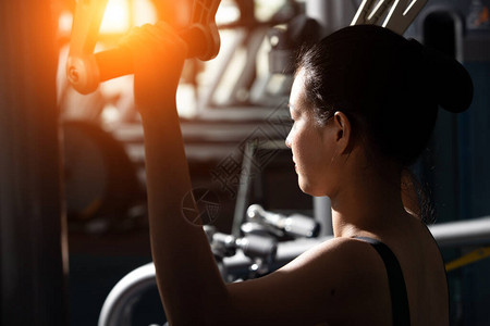 亚洲苗条健身女黑发运动胸罩运动的背面图在健身房推拉机重量肌肉手臂多功能运动时热身概念女可以做运图片