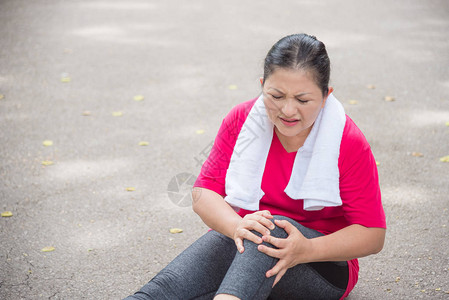 亚洲老年妇女在公园跑步时膝盖脚踝疼痛图片