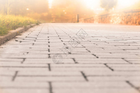 背景的人行道瓷砖纹理与金光在日落时慢跑或散步和散步的路径您图片
