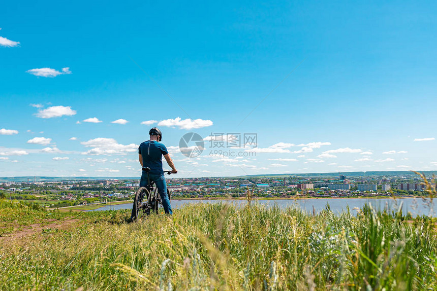 一位男骑自行车的人站在一座小山上图片