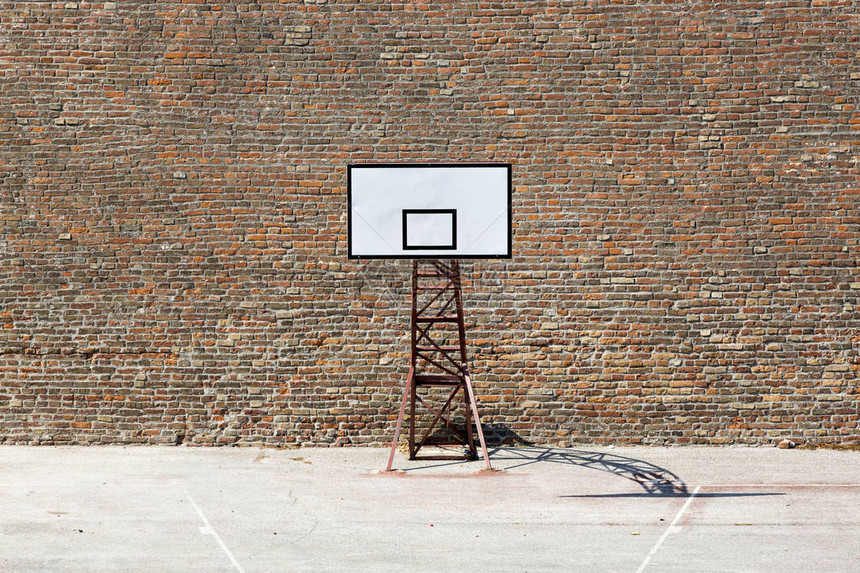 砖墙背景上运动场上的篮球盾牌图片