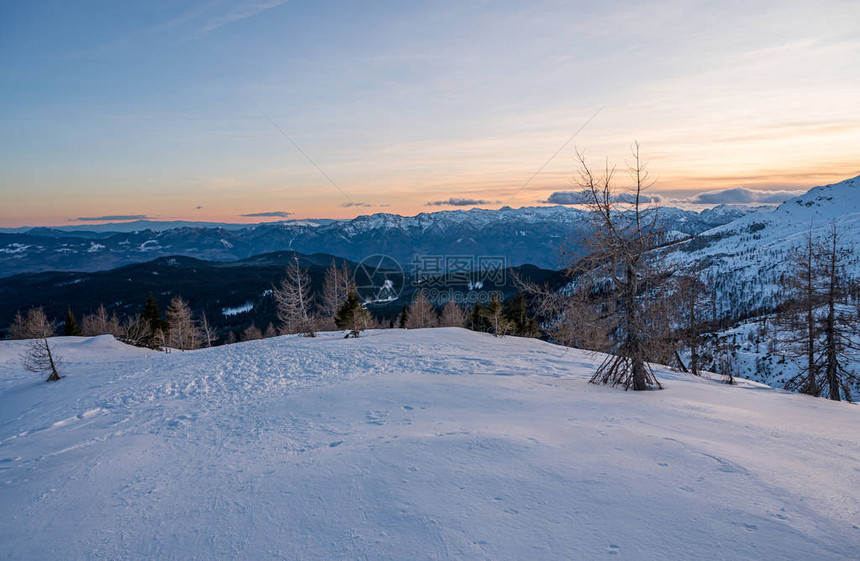 壮观的冬天山全景山在日落太阳在白雪皑的山脊和山峰后落山斯洛文图片