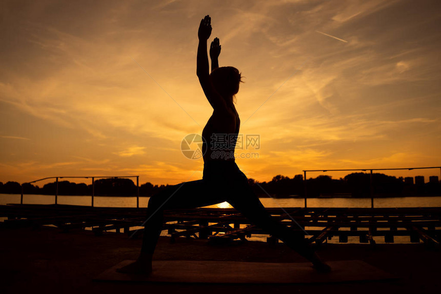 女在日落时练瑜伽维拉巴沙拉萨图片