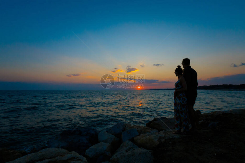 夏季景观与年轻的白种人旅游夫妇在土耳其边的热带海滩上观看金色的日落蜜月期间在天堂场景拍图片