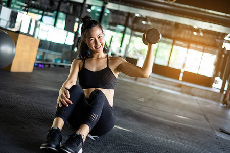 运动美女用哑铃重量训练设备锻炼图片