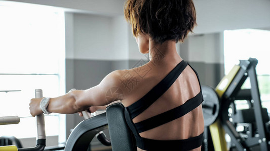 运动型女人正在块模拟器上锻炼脊柱肌肉图片