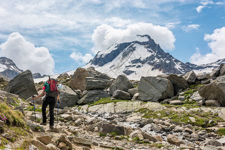 环绕着壮观的山景环绕的石条足迹上的女登山者图片