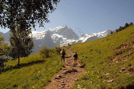 夫妇在法国阿尔卑斯山的一条徒步旅行路上行图片