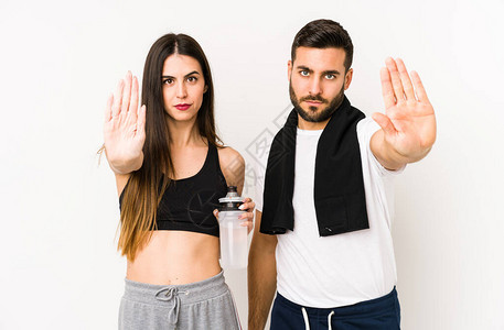 年轻的caucasian健身夫妇孤立的夫妇站在伸展的手显示停图片