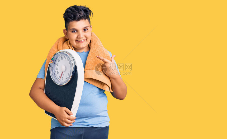 小男孩拿着举重机来平衡减肥用手和指开图片