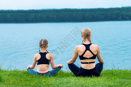 母女俩在湖边的草地上做瑜伽练习图片