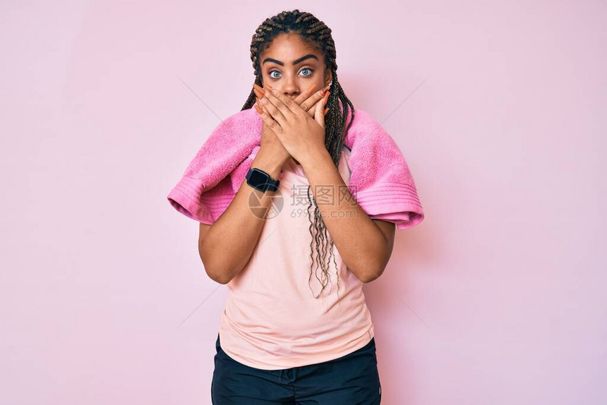 身穿运动服和毛巾的非洲年轻女因错误用手遮住嘴顶而震惊秘密概念图片