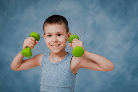 男孩在情感上表现出他的手臂两肢肌肉的强度图片