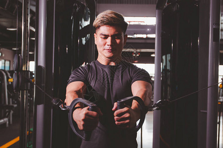 强壮有力的亚洲运动员在室内健身房训练绳索飞行训练图片