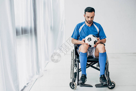 穿着足球制服的男子坐在轮椅上图片