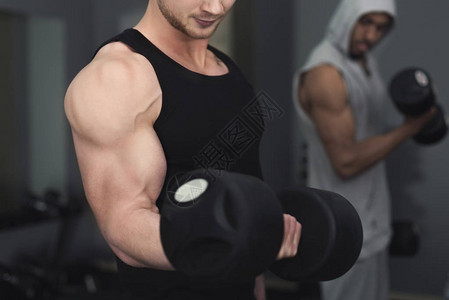 年轻的无法辨认的肌肉健美运动员在现代健身中心做重型硬拉图片