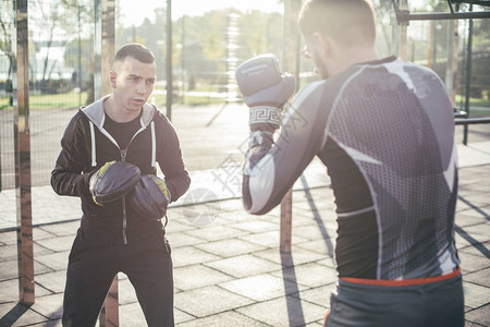 专业训练师在训练期间看着专业MMA拳击手图片
