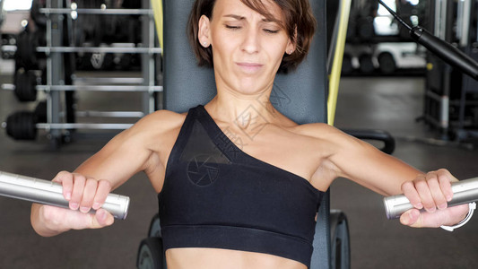 健身房的新人女正在努力推动健身站的手臂肌肉锻炼第一次运动锻炼健图片