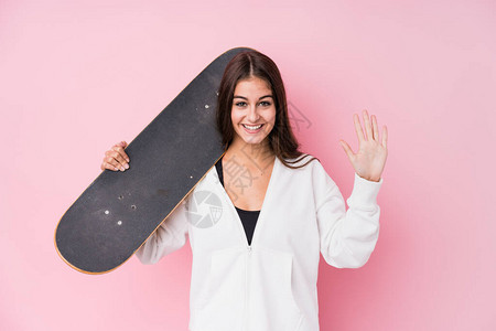年轻的caucasian溜冰女拿着滑冰鞋微笑的容带图片