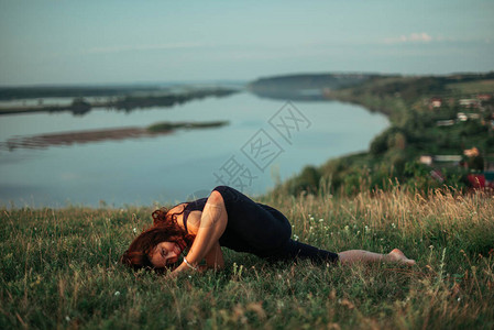 日出时的瑜伽练习和冥想质妇女在大河图片