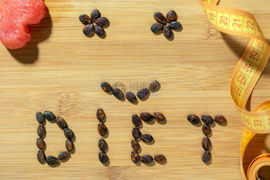 木板上用种子和卷尺制成的饮食词图片