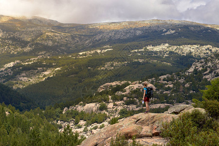 独自一人在山上的女人从岩石看风景图片