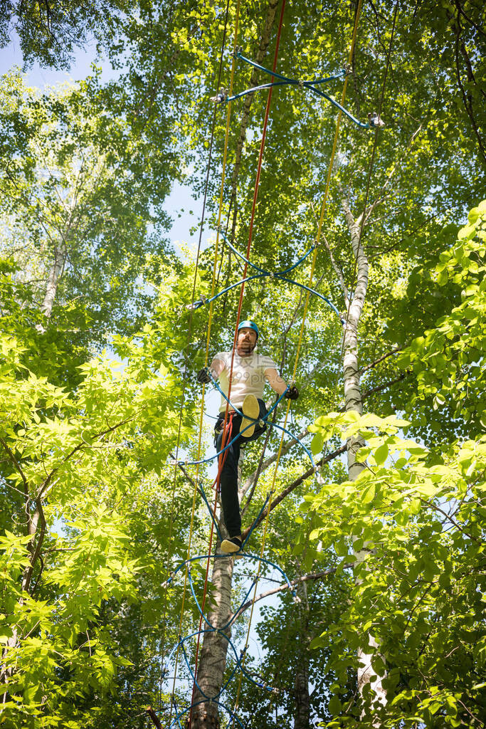 男子走在挂树上的吊索桥上中投图片