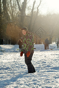 男孩在冬季有乐趣的外出门男孩正在滑雪在冰图片