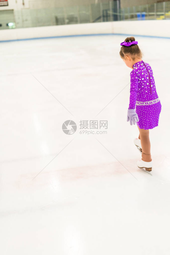 小女孩穿着紫色裙子穿花样滑冰在室内溜冰图片