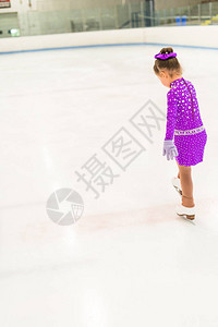 小女孩穿着紫色裙子穿花样滑冰在室内溜冰图片