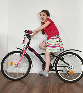 一个孩子骑自行车在房子背景图片