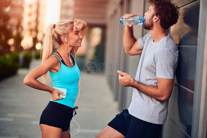 现代男女青年在城市地区慢跑锻炼后暂停活动图片