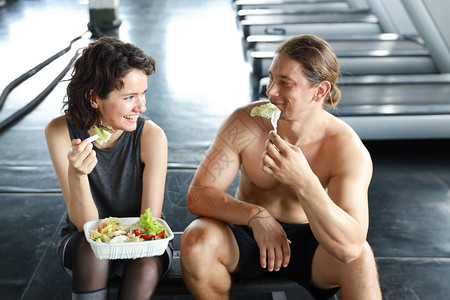 可爱的高加索夫妇健身男女在完成健身训练后在健身房休息并吃沙拉图片