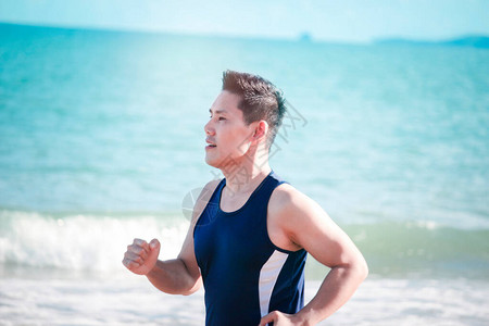 年轻的跑步者在夏季热带岛屿海滩与蓝色大海的户外慢跑图片